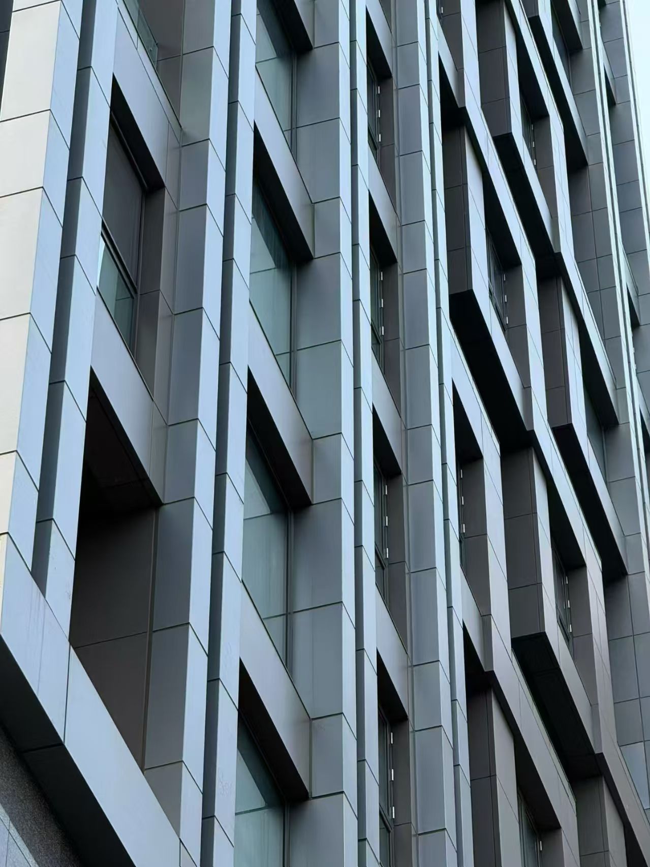 Grey geometric curtain wall with recessed windows